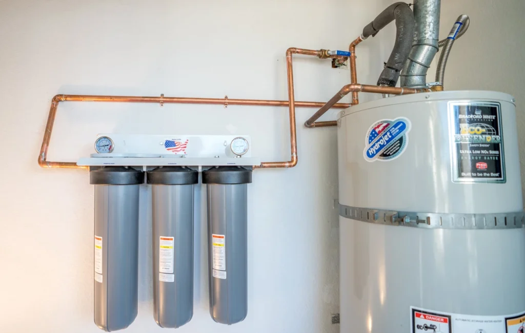 Plumbing technician inspecting a sediment pre-filter as part of a routine whole house water softener service